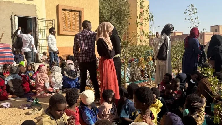 Eine Gruppe von Kindern und Erwachsenen versammelt sich im Freien vor einem Gebäude in Ägypten. Das Bild zeigt ein Hilfseinsatz von STELP.