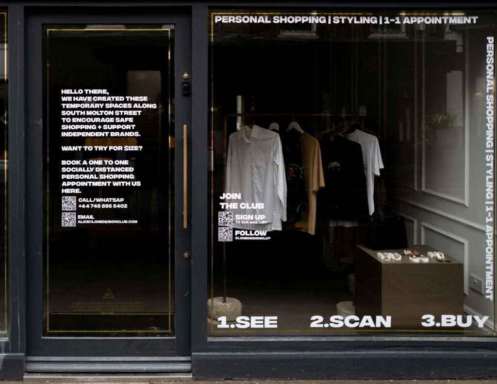 Bild von einem Schaufenster, in dem ausgewählte Kleidungsstücke auf einem Bügel hängen